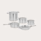 Set of stainless steel cookware including pots and a pan on a light gray background