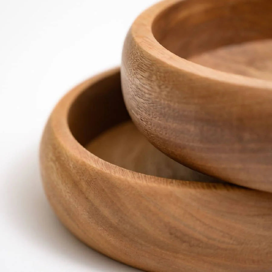 Two wooden bowls stacked on a white background